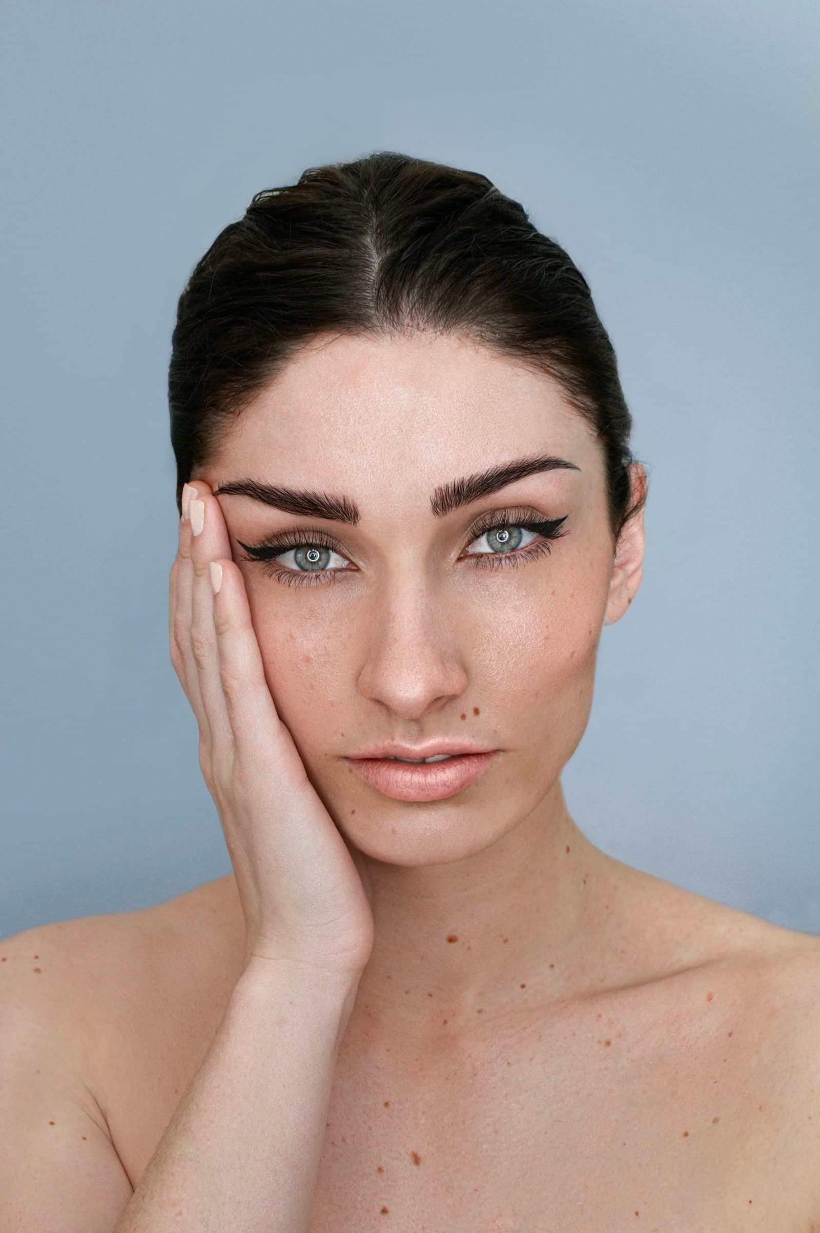 A woman with her hand resting against her cheek