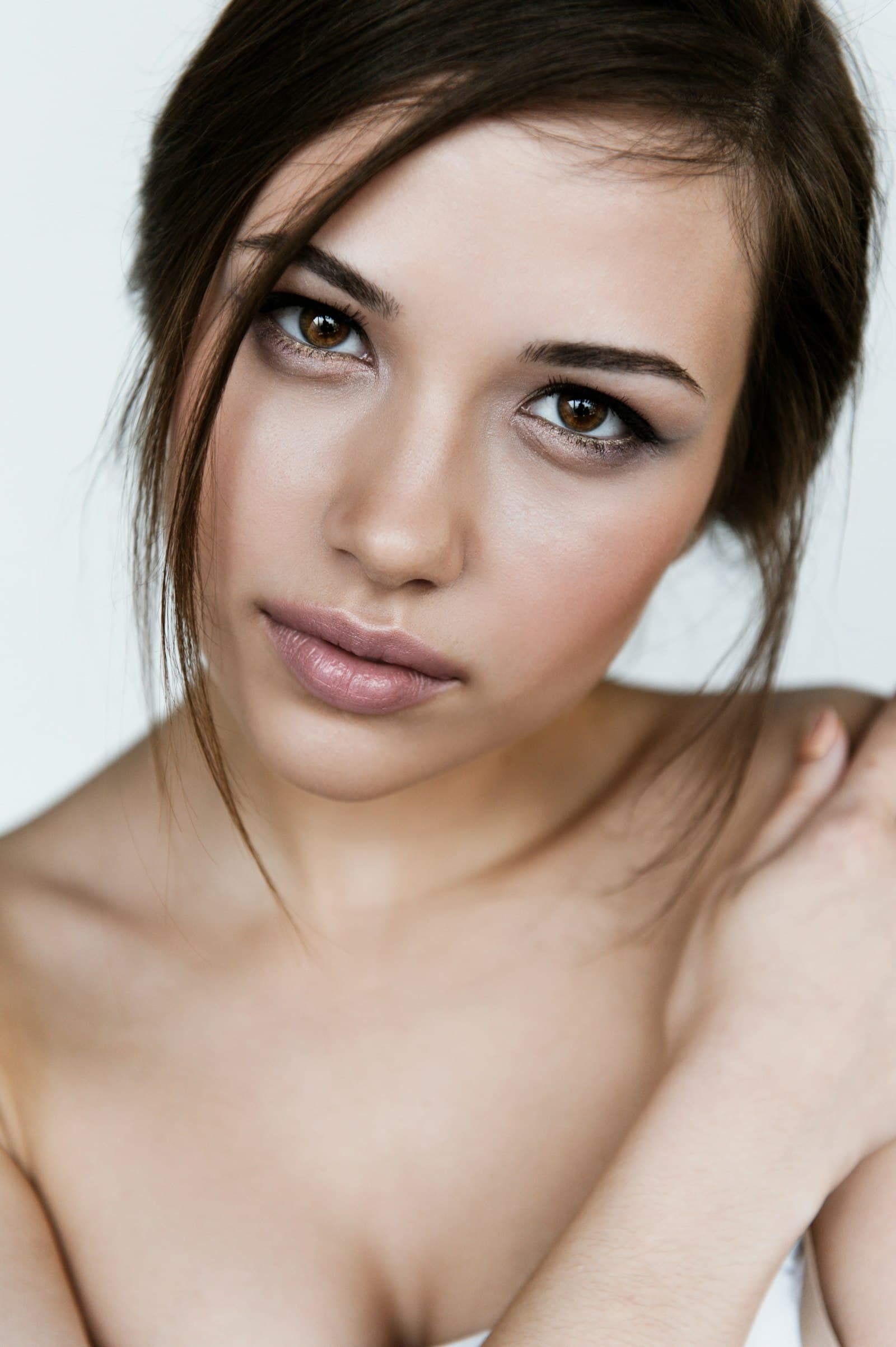 A woman with clear skin and bare shoulders, looking at the camera